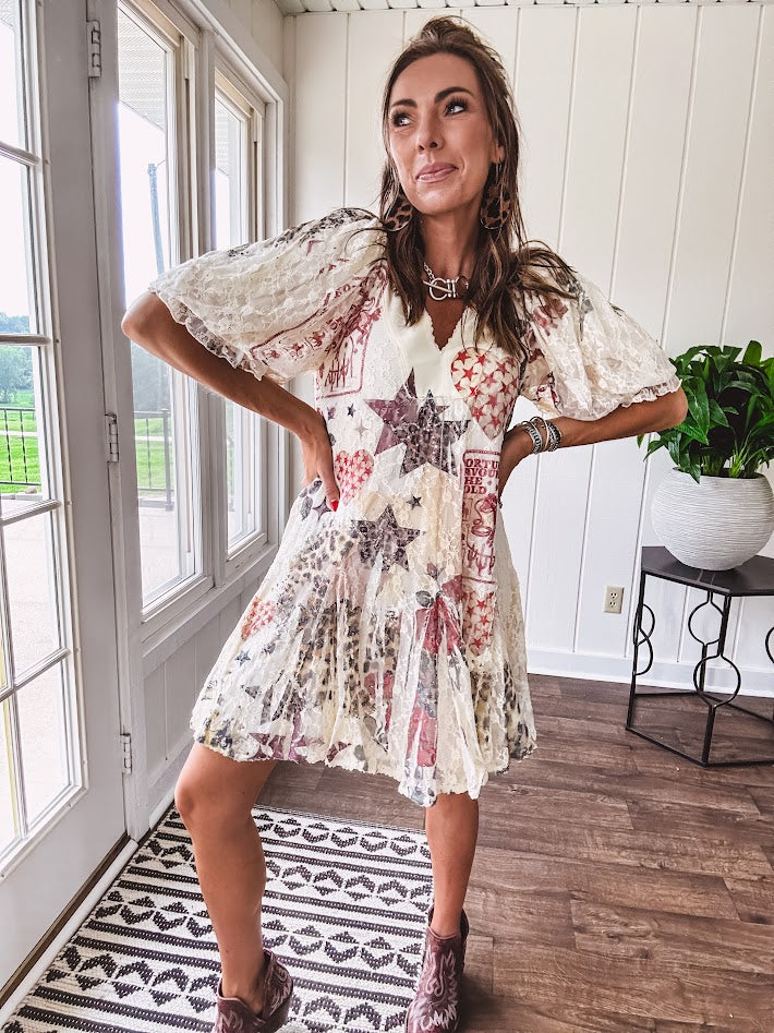 Cream V-neck mini dress with red, taupe, and leopard hearts and stars, lace overlay, ruffled puff sleeves, and an elastic hem. The stretchy, flowy silhouette flatters and flows.