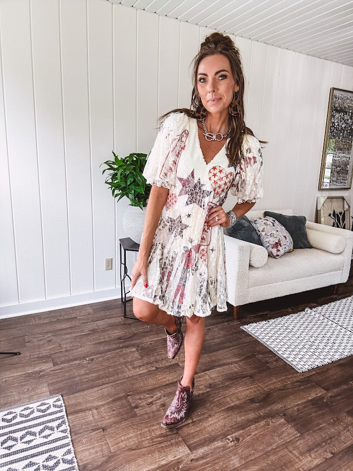 Cream V-neck mini dress with red, taupe, and leopard hearts and stars, lace overlay, ruffled puff sleeves, and an elastic hem. The stretchy, flowy silhouette flatters and flows.
