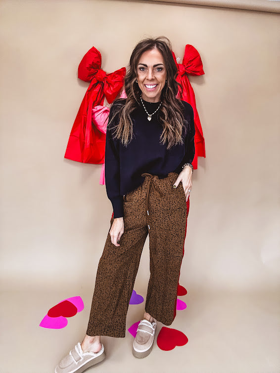 Dark mustard and black leo drawstring waist pants with wide leg.