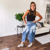 Medium wash midi skirt featuring light and dark wash details throughout with a button and zipper closure and elastic back waist, high front split, side pockets and an upside down design on the bottom. 