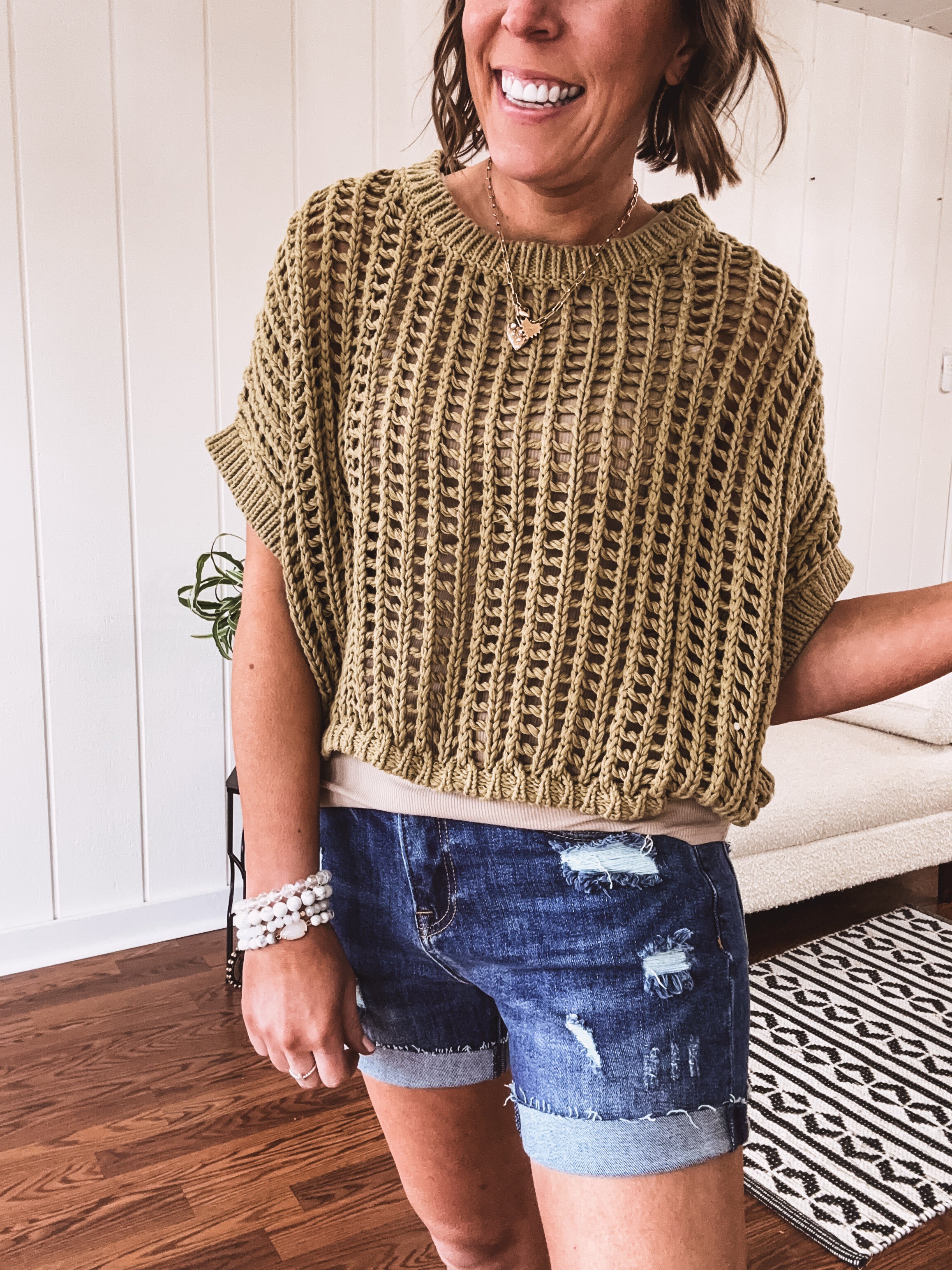 Open weave short sleeved waist length sweater available in many colors.