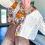 Short hem cotton long sleeved top with boho floral pint patchwork throughout and lace inserts and front pocket with silver button front, Earth tones.