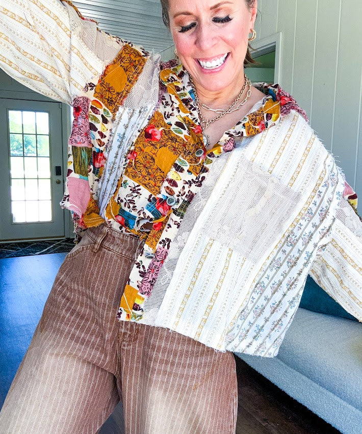 Short hem cotton long sleeved top with boho floral pint patchwork throughout and lace inserts and front pocket with silver button front, Earth tones.