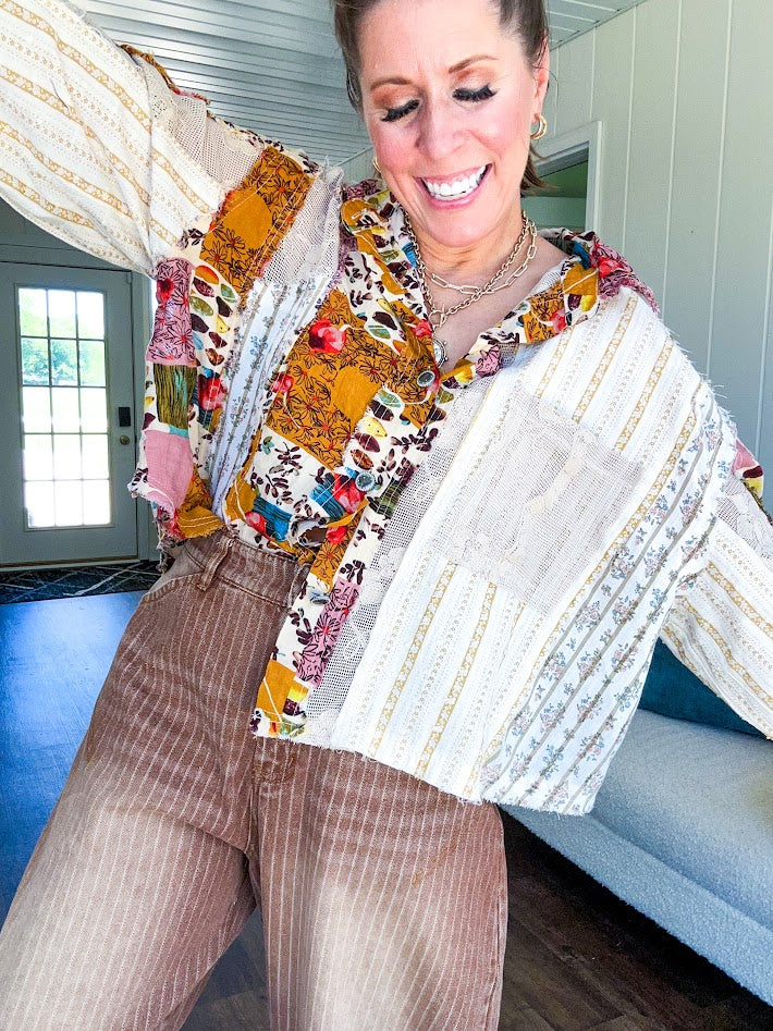 Short hem cotton long sleeved top with boho floral pint patchwork throughout and lace inserts and front pocket with silver button front, Earth tones.