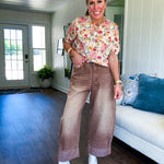 Soft, short sleeved button front sweater with Earth toned florals throughout, faux wooden buttons and round neck.