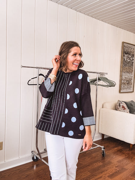 Black V neck sweater with slate blue stripes on one side and polka dots on the other.