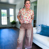 Soft, short sleeved button front sweater with Earth toned florals throughout, faux wooden buttons and round neck.