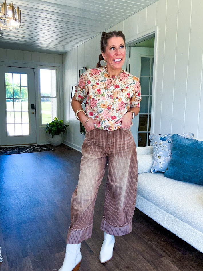 Soft, short sleeved button front sweater with Earth toned florals throughout, faux wooden buttons and round neck.