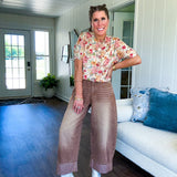 Soft, short sleeved button front sweater with Earth toned florals throughout, faux wooden buttons and round neck.