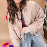 Tan puffer bomber jacket with zipper front and side pockets.