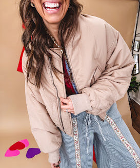 Tan puffer bomber jacket with zipper front and side pockets.