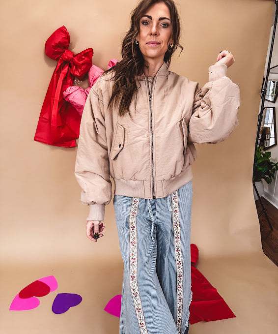Tan puffer bomber jacket with zipper front and side pockets.