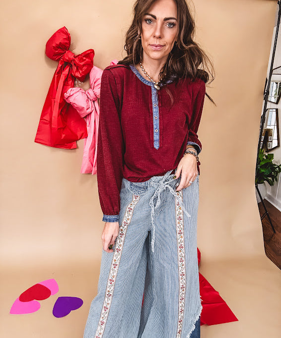 Burgundy Henley style long sleeved top with denim trim at 1/4 button down front, collar and cuffs.