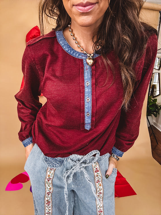 Burgundy Henley style long sleeved top with denim trim at 1/4 button down front, collar and cuffs.