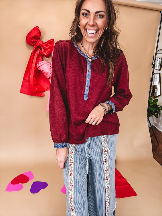 Burgundy Henley style long sleeved top with denim trim at 1/4 button down front, collar and cuffs.
