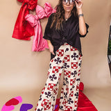 Cream wide leg pants with a spice and chocolate playing card motif pattern, elastic back waist and functional side pockets.