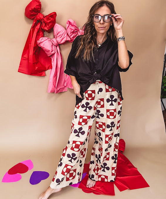 Cream wide leg pants with a spice and chocolate playing card motif pattern, elastic back waist and functional side pockets.
