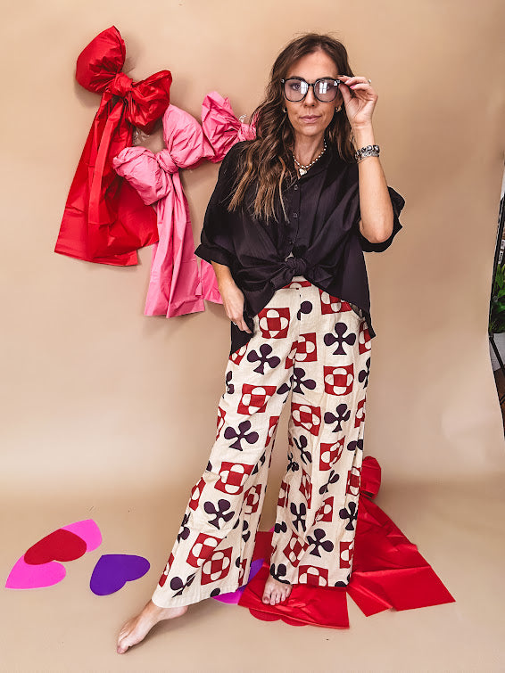 Cream wide leg pants with a spice and chocolate playing card motif pattern, elastic back waist and functional side pockets.
