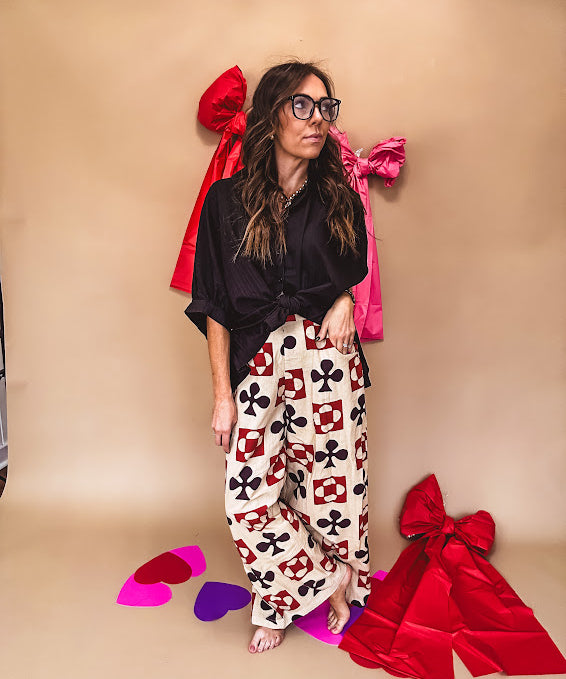 Cream wide leg pants with a spice and chocolate playing card motif pattern, elastic back waist and functional side pockets.