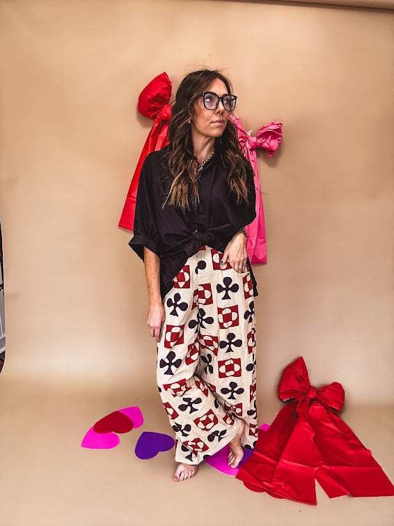 Cream wide leg pants with a spice and chocolate playing card motif pattern, elastic back waist and functional side pockets.