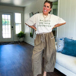 Lightweight mocha utility pant with textured darker mocha striping and contrasting tan and cream mini striping at the elastic drawstring waist and trim on the oversized pocket.