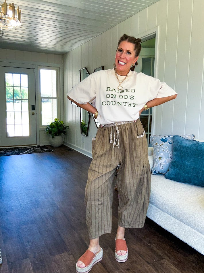 Lightweight mocha utility pant with textured darker mocha striping and contrasting tan and cream mini striping at the elastic drawstring waist and trim on the oversized pocket.