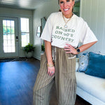 Lightweight mocha utility pant with textured darker mocha striping and contrasting tan and cream mini striping at the elastic drawstring waist and trim on the oversized pocket.
