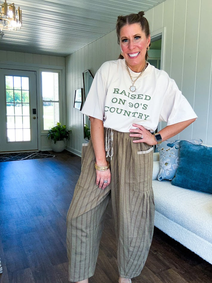 Lightweight mocha utility pant with textured darker mocha striping and contrasting tan and cream mini striping at the elastic drawstring waist and trim on the oversized pocket.