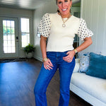 Ivory ribbed round neck short sleeved top with balloon sleeves featuring black polka dots, with a scalloped hem and neckline.