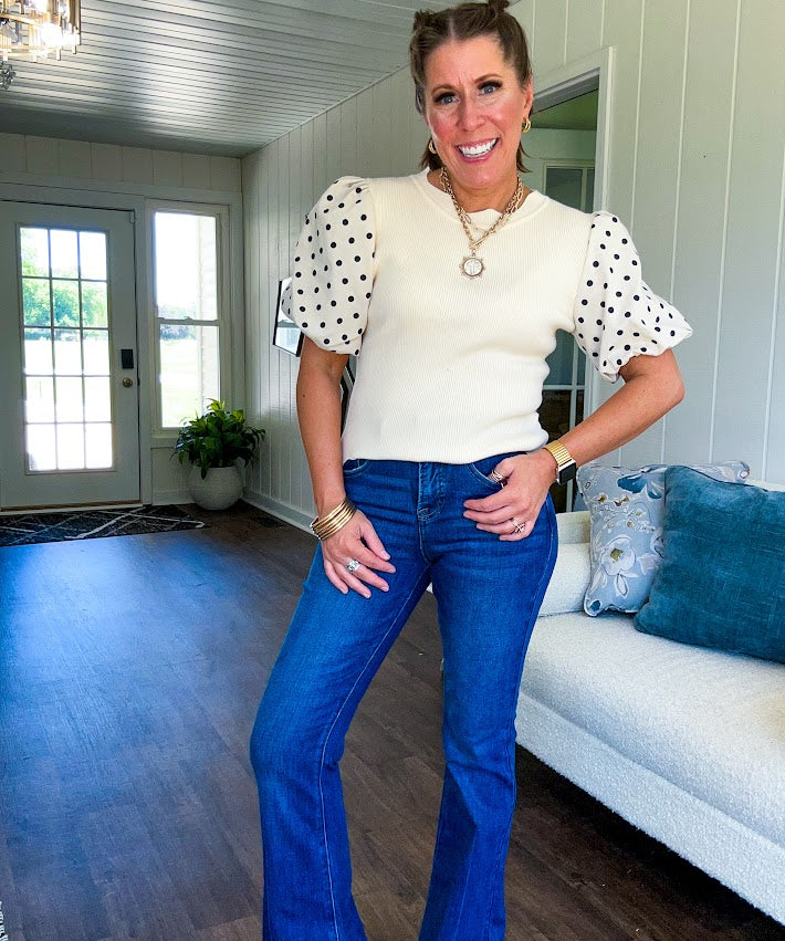 Ivory ribbed round neck short sleeved top with balloon sleeves featuring black polka dots, with a scalloped hem and neckline.
