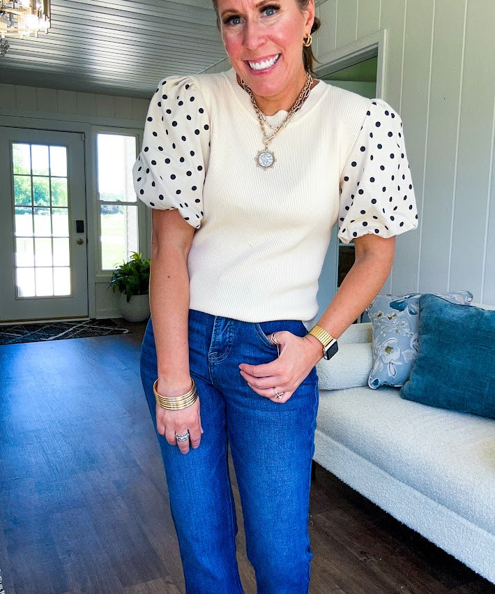 Ivory ribbed round neck short sleeved top with balloon sleeves featuring black polka dots, with a scalloped hem and neckline.