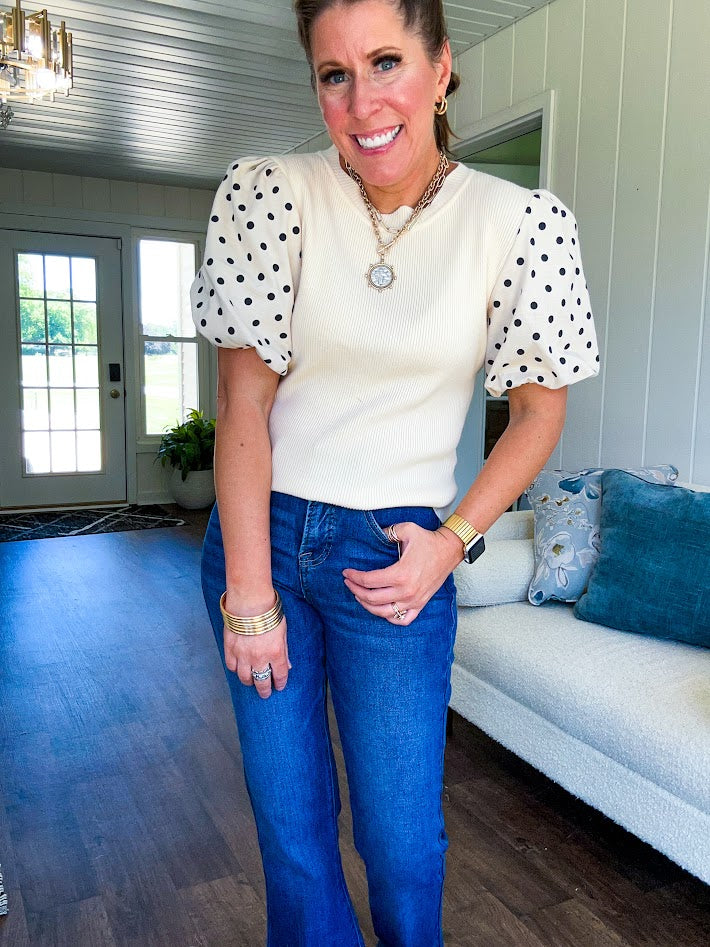 Ivory ribbed round neck short sleeved top with balloon sleeves featuring black polka dots, with a scalloped hem and neckline.