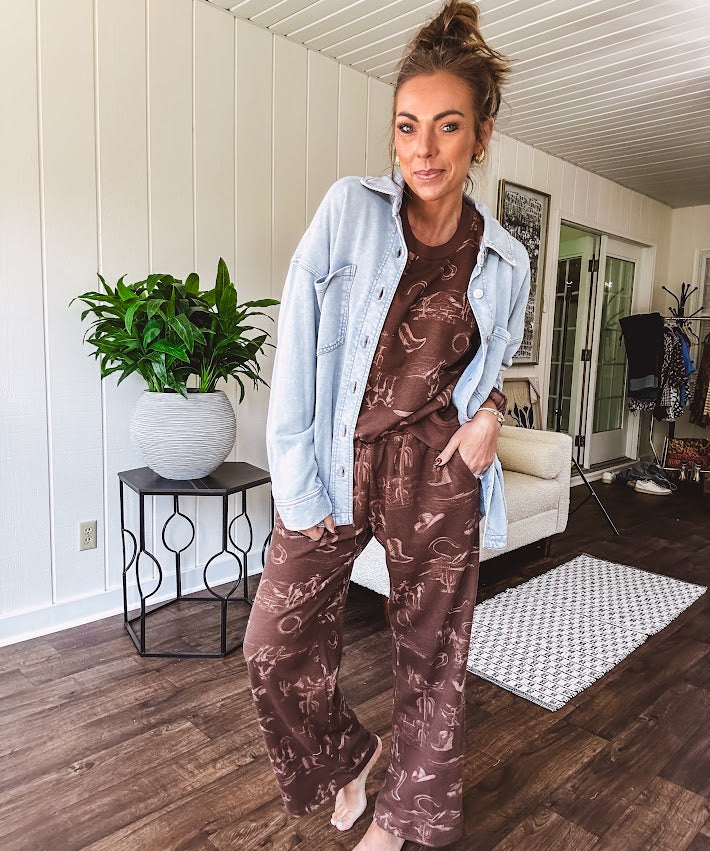 Crafted from a soft cotton-poly blend, these lightweight joggers feature an eye-catching western print complete with boots, hats, horses, and horseshoes across a warm brown base. With wide-leg silhouette, elastic drawstring waist, and functional pockets.