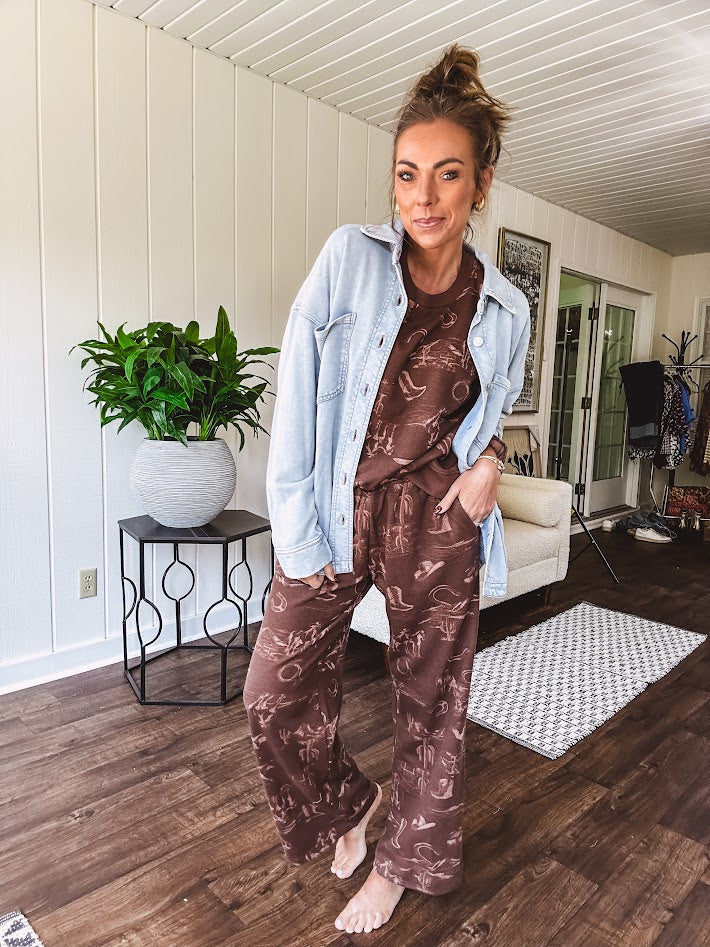 Crafted from a soft cotton-poly blend, these lightweight joggers feature an eye-catching western print complete with boots, hats, horses, and horseshoes across a warm brown base. With wide-leg silhouette, elastic drawstring waist, and functional pockets.