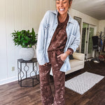 Crafted from a soft cotton-poly blend, these lightweight joggers feature an eye-catching western print complete with boots, hats, horses, and horseshoes across a warm brown base. With wide-leg silhouette, elastic drawstring waist, and functional pockets.