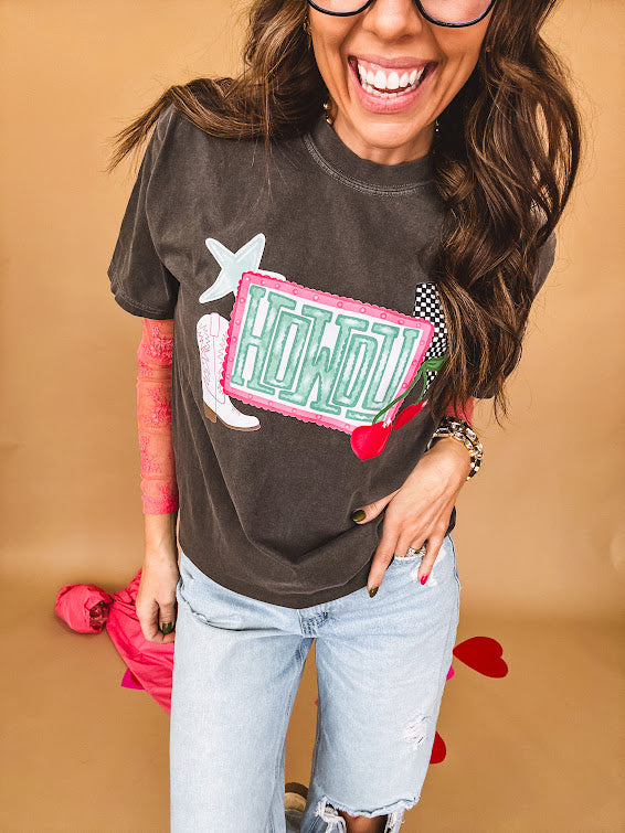Charcoal cotton tee with pink, teal, white and red and "Howdy", cherries and a white and black checkered lightning bolt graphics.