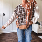 Plaid pullover pairs earth-tone mocha, cream, and rust with playful contrasting stripes on the sleeves with a split neck and relaxed fit.