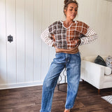High-rise fit with a curved, architectural leg, rigid denim front, stretch fabric, top block, curved outer seam, and tapered hem that create a modern "barrel" or "horseshoe" shape sitting away from the leg.