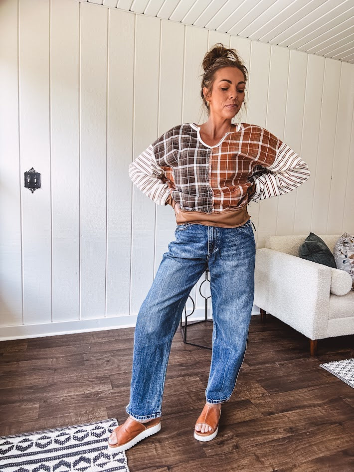 High-rise fit with a curved, architectural leg, rigid denim front, stretch fabric, top block, curved outer seam, and tapered hem that create a modern "barrel" or "horseshoe" shape sitting away from the leg.