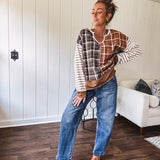 Plaid pullover pairs earth-tone mocha, cream, and rust with playful contrasting stripes on the sleeves with a split neck and relaxed fit.