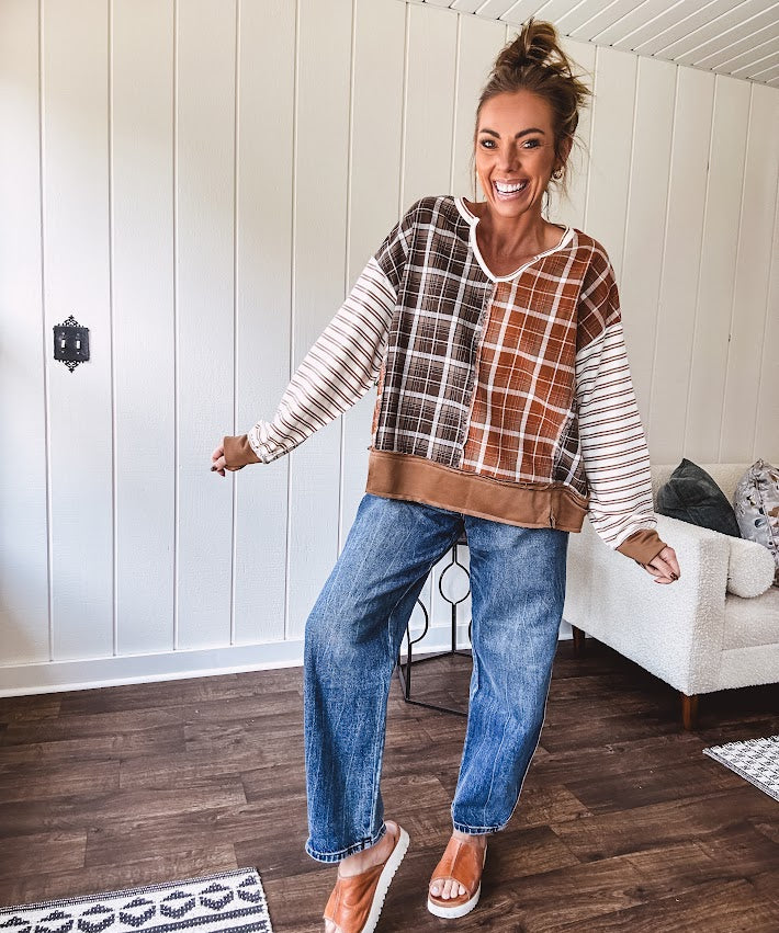 High-rise fit with a curved, architectural leg, rigid denim front, stretch fabric, top block, curved outer seam, and tapered hem that create a modern "barrel" or "horseshoe" shape sitting away from the leg.