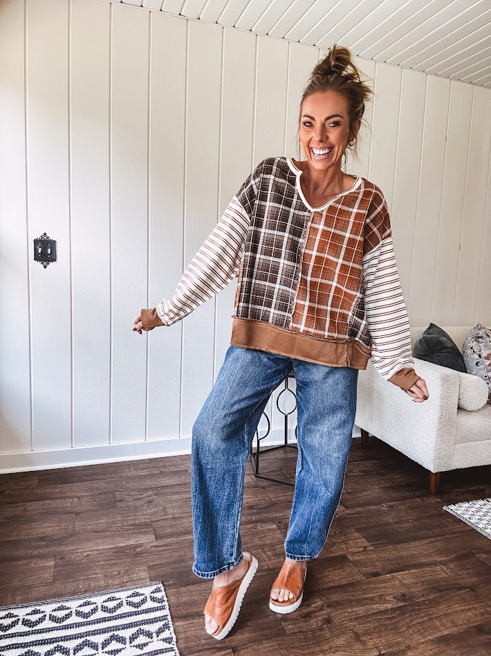 High-rise fit with a curved, architectural leg, rigid denim front, stretch fabric, top block, curved outer seam, and tapered hem that create a modern "barrel" or "horseshoe" shape sitting away from the leg.