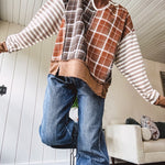 Plaid pullover pairs earth-tone mocha, cream, and rust with playful contrasting stripes on the sleeves with a split neck and relaxed fit.