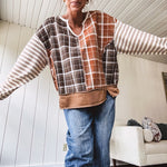 Plaid pullover pairs earth-tone mocha, cream, and rust with playful contrasting stripes on the sleeves with a split neck and relaxed fit.