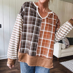 Plaid pullover pairs earth-tone mocha, cream, and rust with playful contrasting stripes on the sleeves with a split neck and relaxed fit.