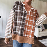 Plaid pullover pairs earth-tone mocha, cream, and rust with playful contrasting stripes on the sleeves with a split neck and relaxed fit.