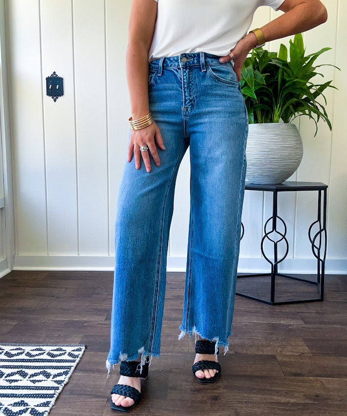 Comfort-stretch denim with a soft, flexible feel
Flattering high-rise fit
Classic five-pocket styling
Unique slant side seam detailing for added dimension
Trendy uneven raw hem finish
Ankle-length wide-leg silhouette
Medium wash denim