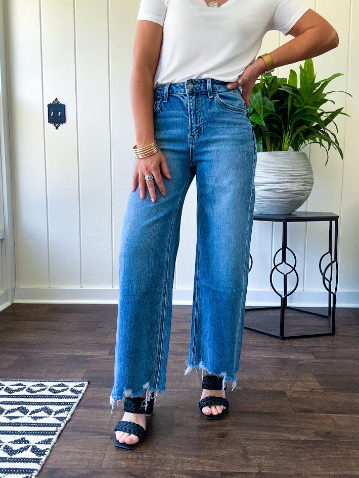Comfort-stretch denim with a soft, flexible feel
Flattering high-rise fit
Classic five-pocket styling
Unique slant side seam detailing for added dimension
Trendy uneven raw hem finish
Ankle-length wide-leg silhouette
Medium wash denim