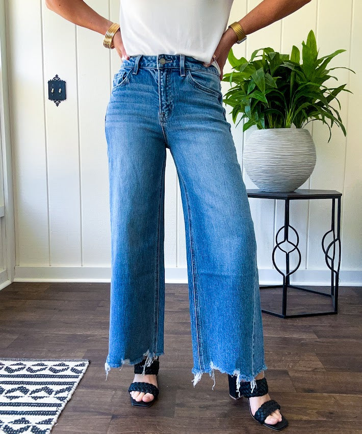 Comfort-stretch denim with a soft, flexible feel
Flattering high-rise fit
Classic five-pocket styling
Unique slant side seam detailing for added dimension
Trendy uneven raw hem finish
Ankle-length wide-leg silhouette
Medium wash denim