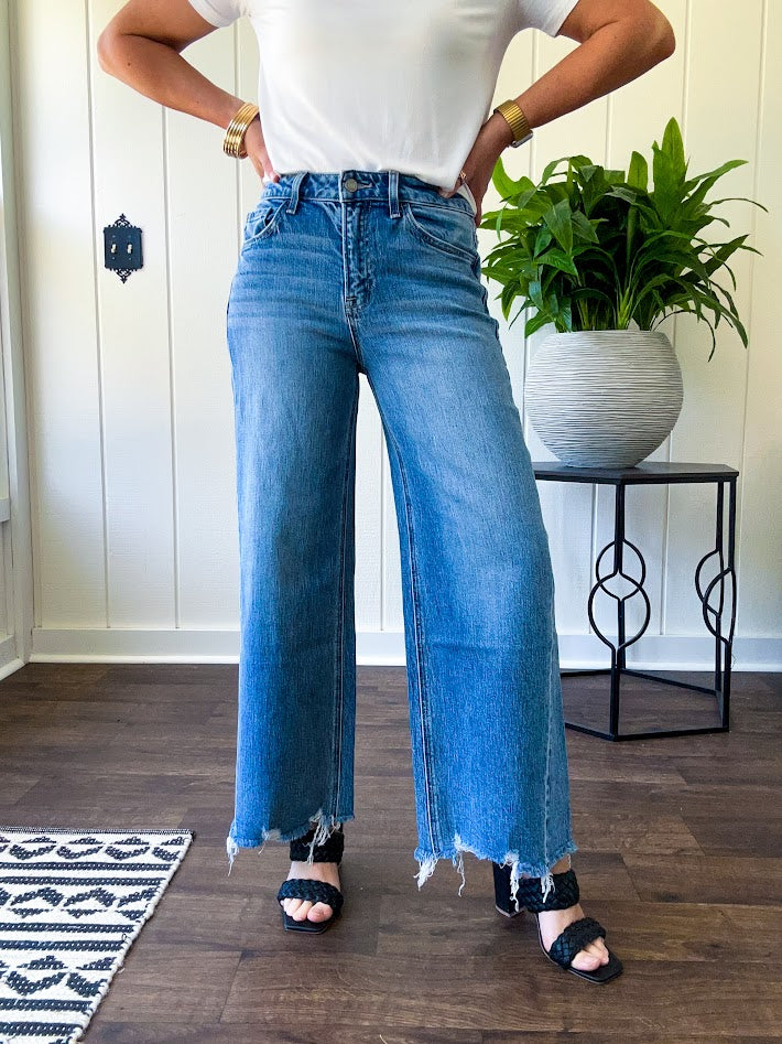 Comfort-stretch denim with a soft, flexible feel
Flattering high-rise fit
Classic five-pocket styling
Unique slant side seam detailing for added dimension
Trendy uneven raw hem finish
Ankle-length wide-leg silhouette
Medium wash denim